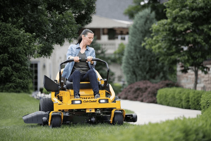 Woman using mower to maintain yard