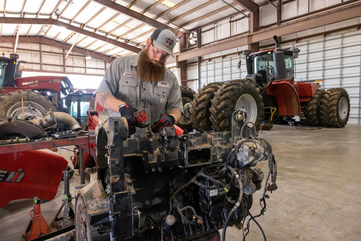 Service tech working on a combine engine